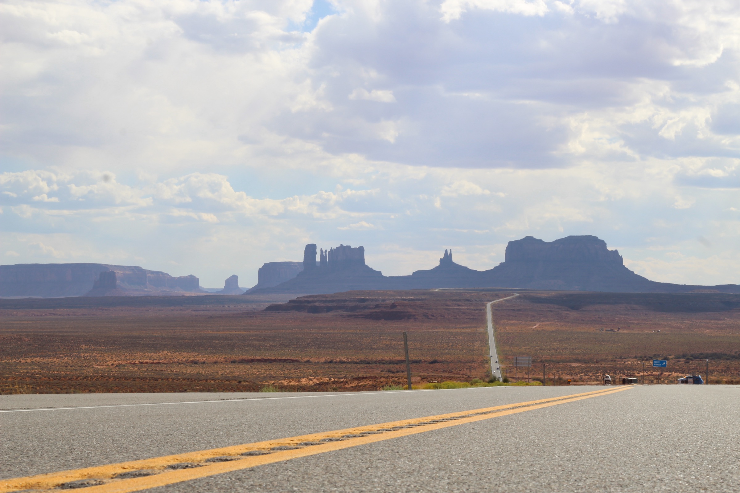 A highway stretching toward the rock formations of Monument Valley